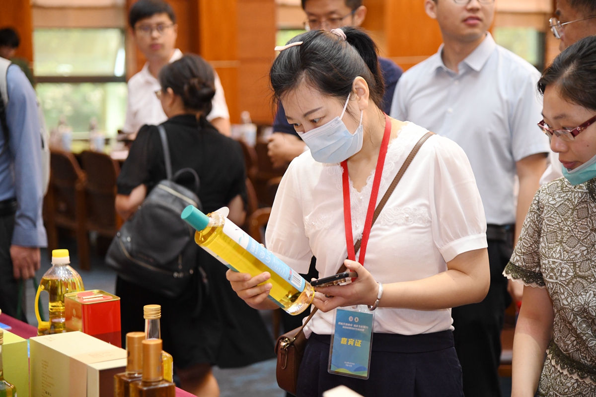 16 与会嘉宾观看高油酸菜籽油（通讯员 徐行 摄）